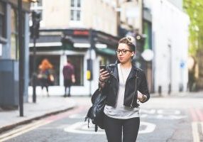 Girl,Walking,Down,The,Street,With,Her,Phone.,A,Woman